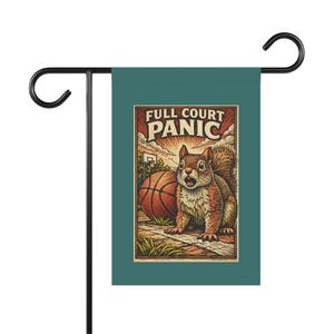 Puede incluir: Una bandera de jardín verde azulado con una ilustración de dibujos animados de una ardilla sorprendida junto a una pelota de baloncesto. La bandera dice "FULL COURT PANIC" en una fuente de estilo vintage.