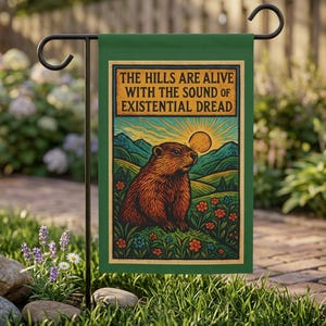 May include: A rectangular green garden flag featuring a brown groundhog sitting in a field of colorful flowers with rolling hills and a sun in the background. The text reads: THE HILLS ARE ALIVE WITH THE SOUND OF EXISTENTIAL DREAD in black letters.