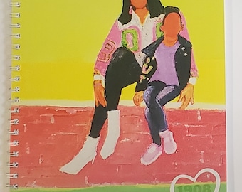 May include: A pink and green notebook featuring an illustration of two people sitting on a brick wall. The notebook has the letters AKA and the year 1908 on the cover.