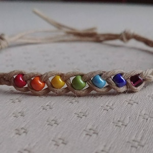May include: A rainbow colored beaded bracelet with a hemp cord.