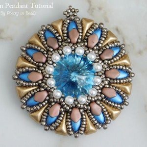 Può includere: Un ciondolo di perline con un centro di cristallo blu, circondato da perline dorate, argentate e rosa. Il ciondolo ha una forma circolare e un design delicato.