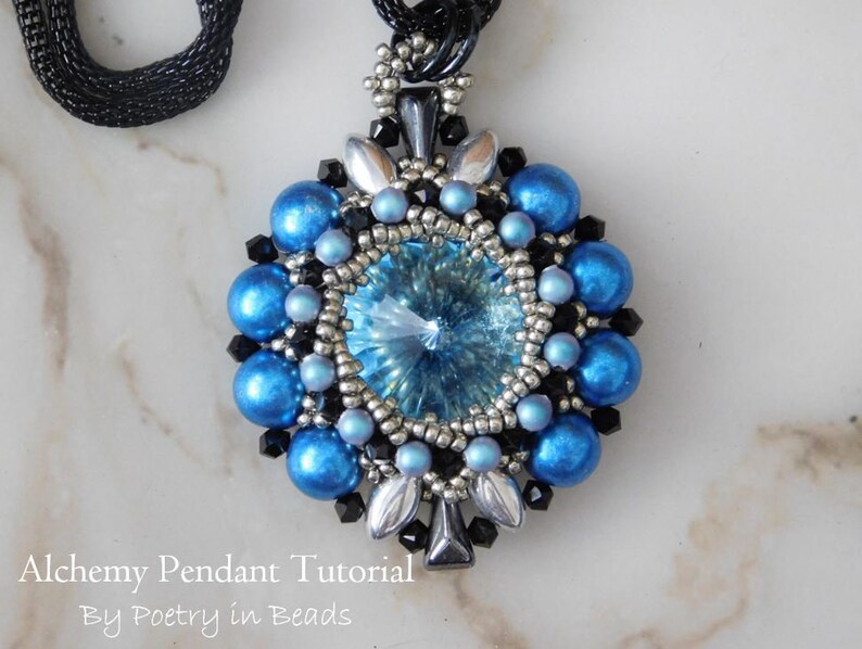 Pode incluir: Um pingente de contas azuis e prateadas com um grande cristal no centro. O pingente est&aacute; pendurado em um cord&atilde;o preto.