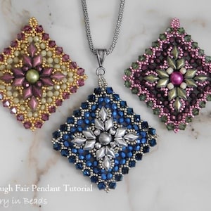 Puede incluir: Tres colgantes de cuentas de forma cuadrada con un diseño de estrella en el centro. Los colgantes son en tonos rosa, verde y azul. El colgante azul está colgado de una cadena plateada.