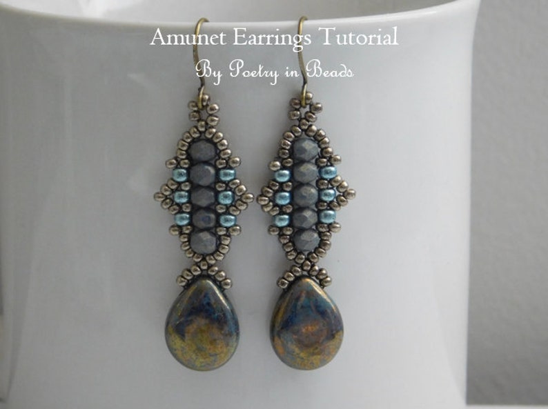 May include: A pair of silver and blue beaded earrings with a teardrop-shaped stone pendant. The earrings are made with seed beads and feature a geometric design. The earrings are called "Amulet Earrings" and the tutorial is by "Poetry in Beads".