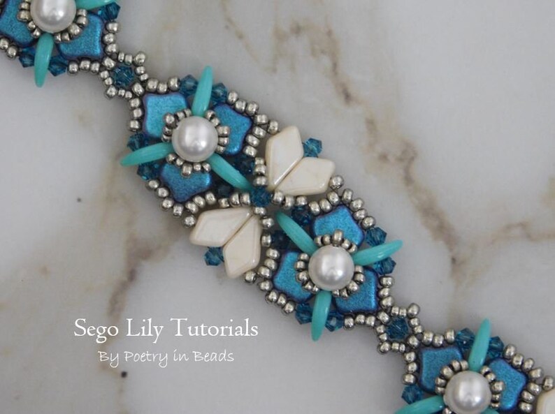 May include: A close-up of a beaded bracelet with a turquoise and white color scheme. The bracelet features a repeating pattern of flowers and leaves. The text "Sego Lily Tutorials By Poetry in Beads" is visible at the bottom of the image.