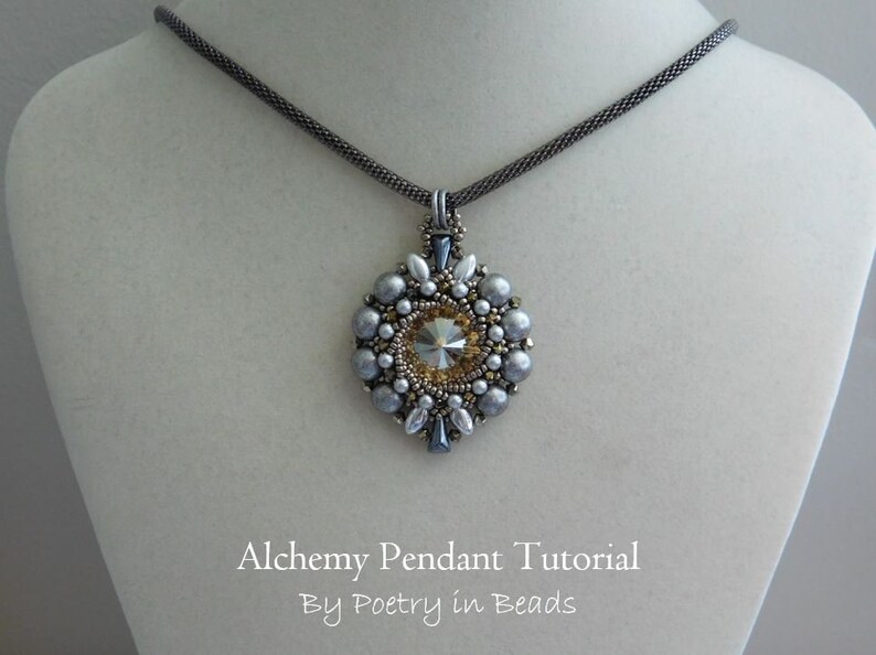 Pode incluir: Um colar de corrente prateada com um pingente de contas prateadas e douradas com um grande cristal transparente no centro. O pingente tem a forma de uma flor com um design de estrela. O texto "Alchemy Pendant Tutorial By Poetry in Beads" est&aacute; abaixo do pingente.