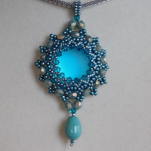 May include: A teal blue pendant necklace with a round, beaded design and a teardrop-shaped gemstone hanging from the bottom.