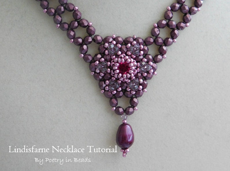 May include: A close-up of a purple and pink beaded necklace with a flower-shaped pendant and a single purple bead hanging from the bottom. The necklace is made with small, faceted beads and has a delicate, intricate design.