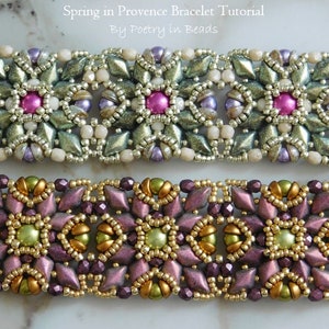 以下が含まれることがあります： 花柄のビーズブレスレットが2つ。上のブレスレットは緑、白、紫のビーズにピンクのアクセントが施されています。下のブレスレットは金、緑、紫のビーズでできています。