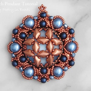 Puede incluir: Un colgante de cuentas de cobre y azul con un dise&ntilde;o de estrella. El colgante est&aacute; hecho con cuentas de semillas y cuentas redondas m&aacute;s grandes.