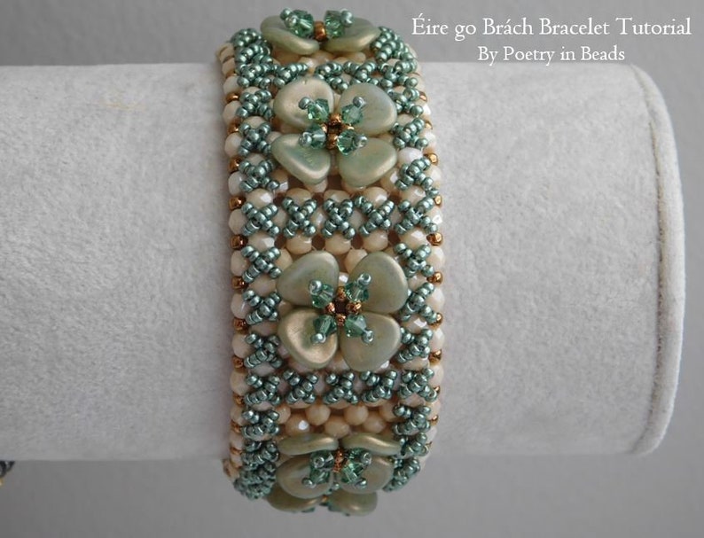 Pu&ograve; includere: Un braccialetto di perline con un design floreale verde e bianco. Il braccialetto &egrave; realizzato con piccole perline a seme e perline pi&ugrave; grandi, piatte e madreperlacee. Il titolo "&Eacute;ire go Br&aacute;ch Bracelet Tutorial By Poetry in Beads" &egrave; visibile nell'immagine.