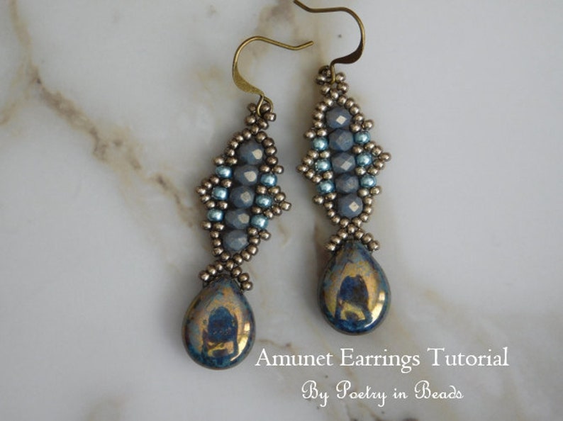 May include: A pair of silver and blue beaded earrings with a teardrop-shaped iridescent blue stone at the bottom. Amunet Earrings Tutorial by Poetry in Beads.