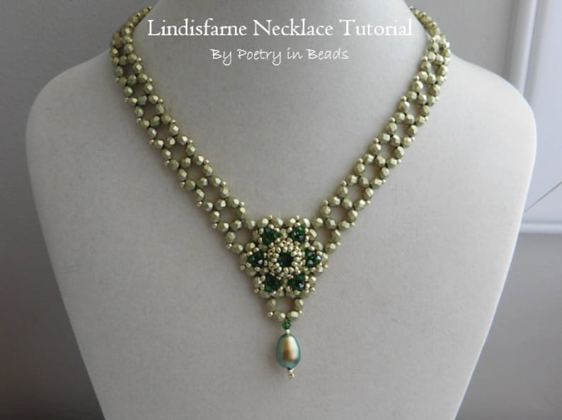 May include: A green and gold beaded necklace with a flower pendant and a pearl drop. The necklace is on a white mannequin bust. The text "Lindisfarne Necklace Tutorial By Poetry in Beads" is at the top of the image.