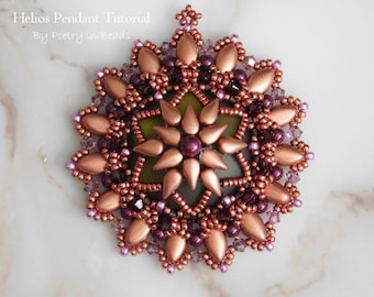 Puede incluir: Un colgante de cuentas de cobre y morado con un diseño de estrella. El colgante está hecho con cuentas de semillas y cuentas más grandes en forma de lágrima. El colgante está sobre una superficie de mármol blanco.