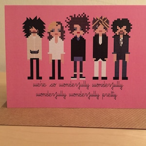 May include: A pink greetings card featuring a pixelated illustration of five figures in various outfits. The text "we're so wonderfully wonderfully wonderfully wonderfully pretty" is written below the figures.