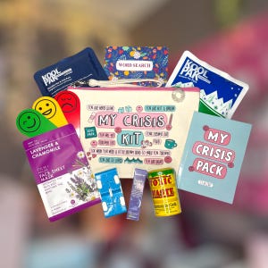 May include: A self-care kit featuring a canvas pouch with "My Crisis Kit" printed on it, alongside a face mask, word search, and a small book. The kit includes a cool pack, a fidget toy, and a lavender roll-on.