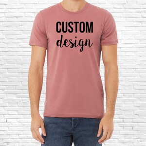 May include: A heather rose colored t-shirt with the text "CUSTOM design" printed in black.