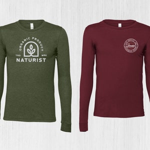 K&ouml;nnte beinhalten: Zwei Langarmshirts, eines gr&uuml;n mit einem wei&szlig;en Logo, auf dem "Organic Product Trd Mrk Naturist" steht, und das andere weinrot mit einem wei&szlig;en Logo, auf dem "Los Angeles CA Hardware House" steht.