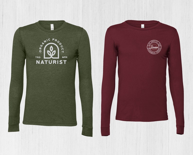 K&ouml;nnte beinhalten: Zwei Langarmshirts, eines gr&uuml;n mit einem wei&szlig;en Logo, auf dem "Organic Product Trd Mrk Naturist" steht, und das andere weinrot mit einem wei&szlig;en Logo, auf dem "Los Angeles CA Hardware House" steht.