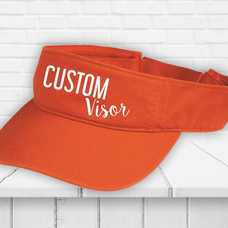 May include: Orange custom visor with white text that reads "CUSTOM Visor".