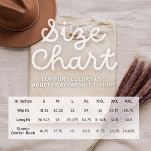 May include: Size chart for a heavyweight t-shirt in various sizes from S to 4XL. The chart shows measurements in inches for width, length, and sleeve length.