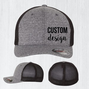 May include: A gray and black baseball cap with a black mesh back. The front of the cap has the text "CUSTOM design" in black.