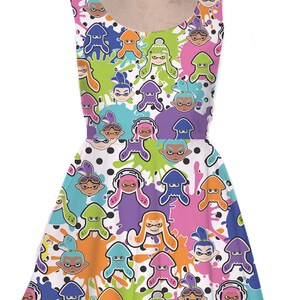 May include: A white sleeveless dress with a colorful print of cartoon characters from the video game Splatoon. The characters are wearing different colored outfits and have different colored ink splatters around them.