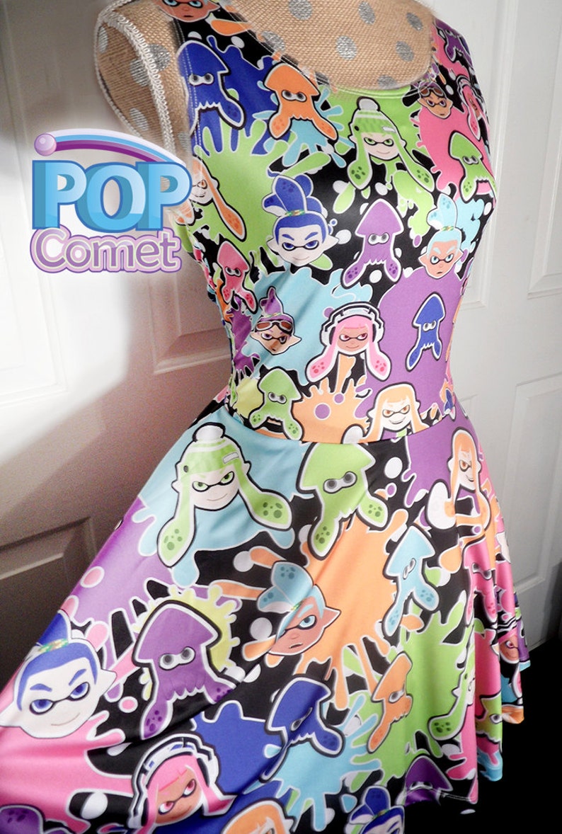 May include: A colorful sleeveless dress with a black background and a repeating pattern of cartoon squid and ink splatters. The dress has a fitted bodice and a flared skirt.