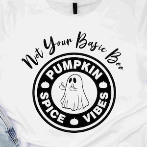 Puede incluir: Camiseta blanca con un diseño negro. El diseño dice "Not Your Basic Boo" y presenta un fantasma haciendo una peineta. El diseño incluye las palabras "Pumpkin Spice Vibes" e ilustraciones de calabazas.