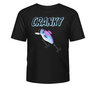 Könnte beinhalten: Schwarzes T-Shirt mit einer Grafik eines Angelköders und dem Wort "CRANKY". Der Köder ist blau, rosa und weiß, mit Haken. Der Text ist in Blau und Weiß. Ein lässiges T-Shirt für den Alltag.