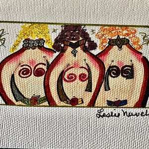 Pode incluir: Uma pintura de três mulheres com cabelo vermelho, amarelo e castanho. Elas estão usando joias coloridas e têm redemoinhos pintados em seus peitos. A pintura é assinada "Leslie Newell".