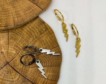 Pode incluir: Dois pares de brincos de argola com pingentes em forma de raio. Um par tem acabamento em tom dourado polido, enquanto o outro par apresenta um acabamento em tom prateado metálico escuro. Cada brinco consiste em uma pequena argola circular.