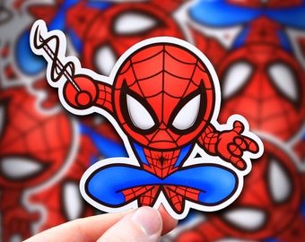 May include: A red and blue cartoon Spider-Man sticker with a web shooter in his hand. The sticker is on a white background.