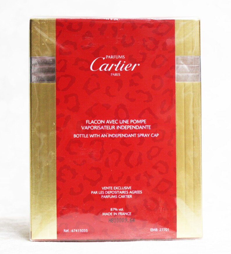 Pu&ograve; includere: Scatola rossa e dorata con il testo "PARFUMS Cartier PARIS" e "FLACON AVEC UNE POMPE VAPORISATEUR INDEPENDANTE BOTTLE WITH AN INDEPENDANT SPRAY CAP". La scatola include anche il testo "VENTE EXCLUSIVE PAR LES DEPOSITAIRES AGREES PARFUMS CARTIER 87% vol. MADE IN FRANCE H810009.64 EMB. 27701" e il numero di riferimento "Ref.: 67415035".