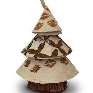 May include: A three-tiered Christmas tree ornament made of natural materials. The tree is decorated with brown and white geometric patterns and has a brown coconut fiber base.