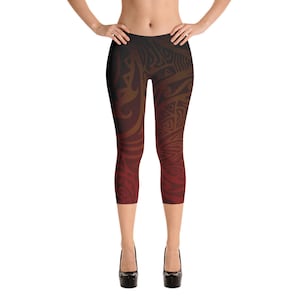 May include: Capri-length leggings with a tribal design. The leggings feature a gradient of colors, transitioning from black at the top to shades of brown and red at the bottom. The intricate pattern covers the entire garment.