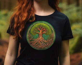 May include: A woman with long red hair stands in a forest wearing a black t-shirt with a green and gold tree of life design.