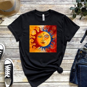 May include: Black t-shirt featuring a colourful sun illustration with a face, set against a yellow background with blue and red accents.