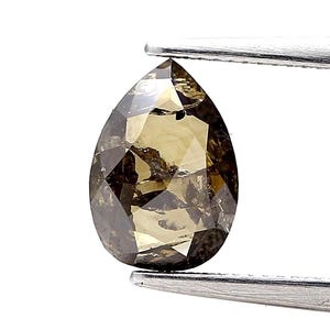 Puede incluir: Un diamante en forma de pera, facetado, sostenido por unas pinzas plateadas. La gema presenta una mezcla de tonos marrones y amarillos, con inclusiones internas visibles. El corte del diamante revela múltiples facetas.