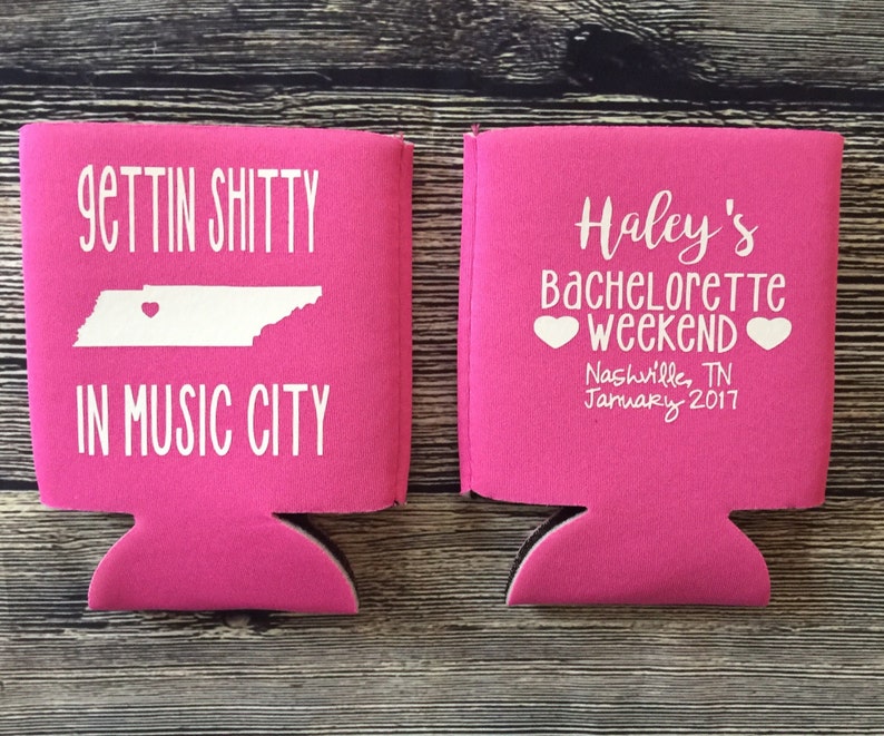 May include: Two pink can coolers with white text. One cooler says "Gettin' Shitty in Music City" with an outline of Tennessee and a heart. The other cooler says "Haley's Bachelorette Weekend" with two hearts and "Nashville, TN January 2017".