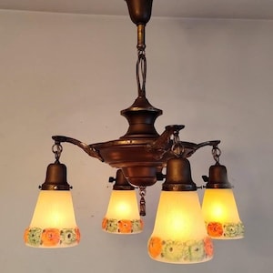 May include: A vintage brass chandelier with four frosted glass shades featuring a floral design. The shades are a pale yellow with orange and green flowers.