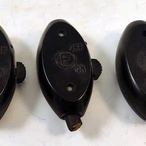 May include: Four black toggle switches with the words "ON" and "OFF" printed on them. Each switch has a small knob on the side.