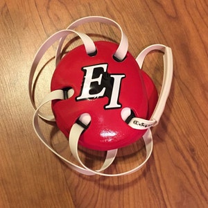 May include: Red headgear with white straps and the letters "EI" in white on a black background.