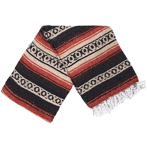 Puede incluir: Una manta mexicana de rayas rojas, negras y crema con un borde de flecos. La manta tiene un patrón tradicional con diseños geométricos.