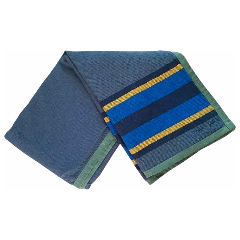 May include: A folded blue towel with a striped section featuring blue and yellow stripes. The towel has a green border and the text "west path" is visible. The towel is made of a soft material.