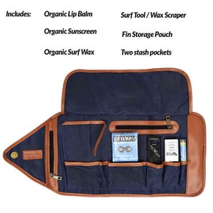 Puede incluir: Organizador de herramientas de surf azul y marr&oacute;n con m&uacute;ltiples bolsillos y compartimentos. Incluye b&aacute;lsamo labial org&aacute;nico, protector solar y cera de surf. Cuenta con cierre de cremallera y una bolsa para guardar aletas. El texto "Red Path" es visible.