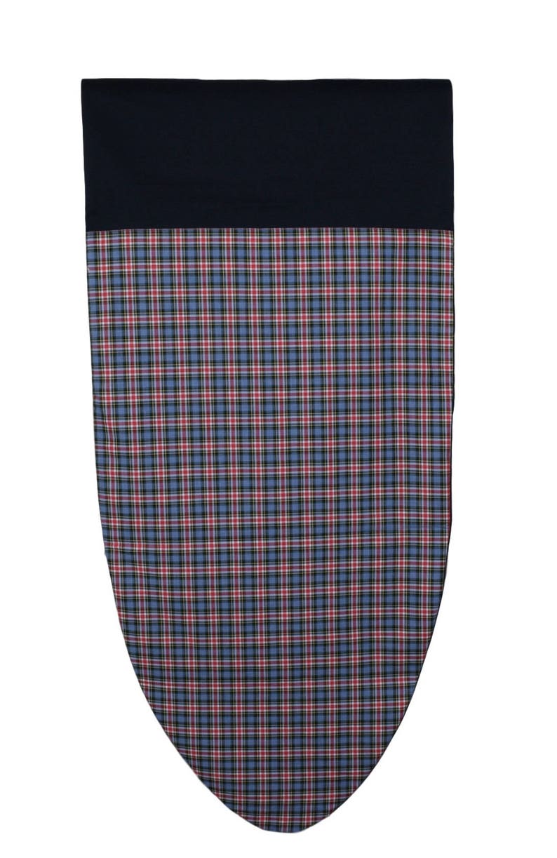 May include: A navy blue and plaid patterned fabric item. The top portion is solid navy blue, while the lower section features a blue, red, and black plaid design. The item has a rounded, shield-like shape.