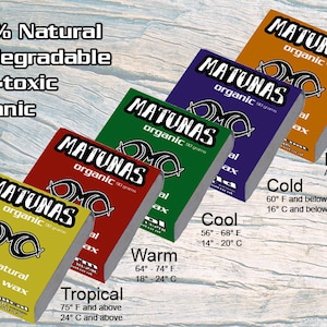 Puede incluir: Una colecci&oacute;n de barras de cera de surf org&aacute;nica Matunas en varios colores, incluyendo amarillo, rojo, verde, morado y naranja. Cada barra est&aacute; etiquetada con rangos de temperatura y el texto "100% Natural, Biodegradable, Non-toxic, Organic".