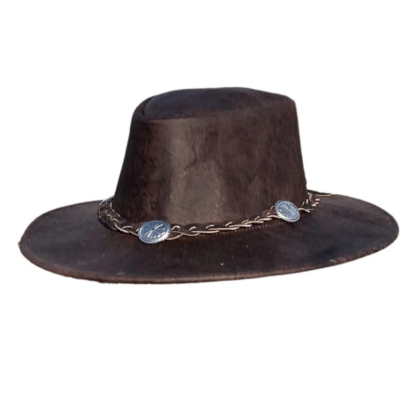 May include: A brown leather cowboy hat with a braided leather band and silver accents.