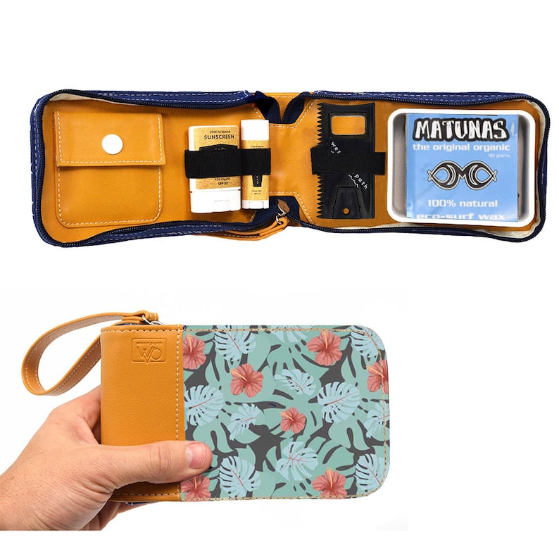 May include: A tan leather zippered pouch with a tropical leaf print on the front. The pouch is open to reveal a small pocket, two tubes of sunscreen, a surfboard wax comb, and a blue container of surfboard wax. The container has the text "Matunas the original organic surf wax 100% natural".